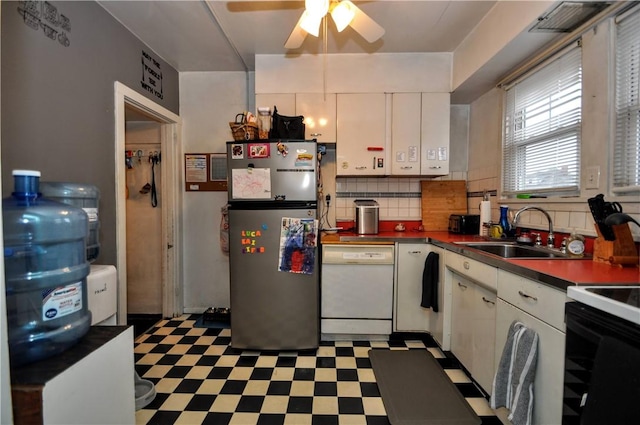 kitchen featuring sink, white cabinetry, tasteful backsplash, stainless steel refrigerator, and white dishwasher