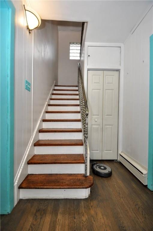 staircase with hardwood / wood-style floors and a baseboard radiator