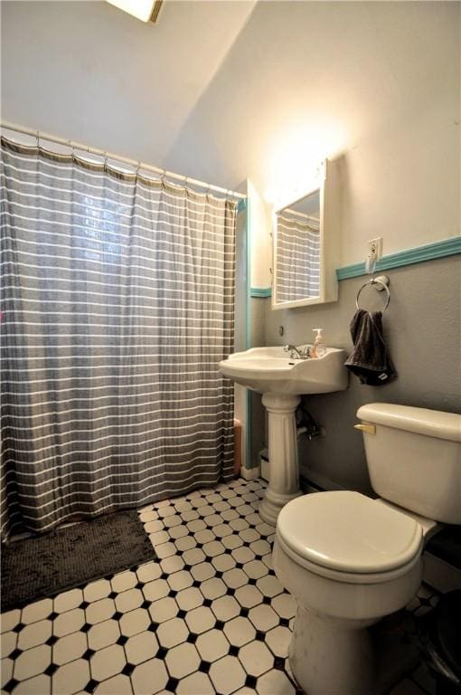 bathroom featuring lofted ceiling, sink, and toilet