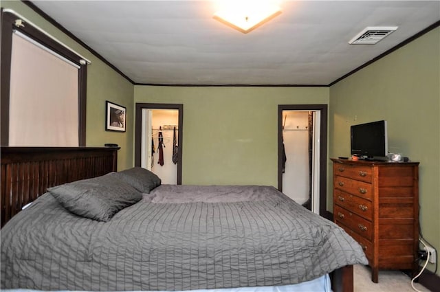 bedroom with crown molding, a walk in closet, and a closet