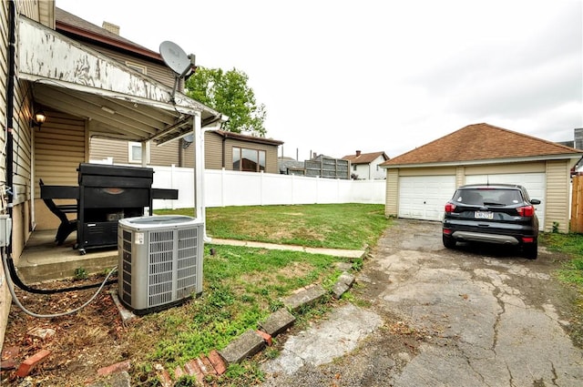 view of yard featuring a garage, an outdoor structure, and central air condition unit