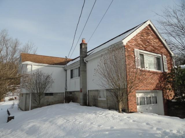 snow covered house with brick siding and a chimney