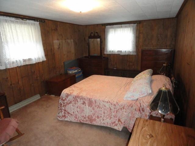 carpeted bedroom featuring wooden walls