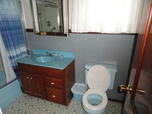 bathroom with toilet, shower / bathtub combination with curtain, vanity, and tile patterned floors