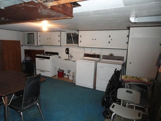 interior space with a sink, washing machine and dryer, white cabinetry, and white range with gas cooktop