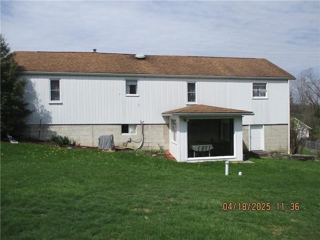 back of house with a yard and roof with shingles