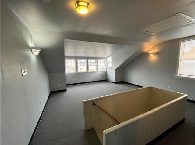 additional living space featuring vaulted ceiling and carpet floors