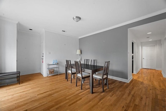 dining area with hardwood / wood-style floors and ornamental molding