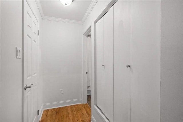 hall with light hardwood / wood-style flooring and ornamental molding