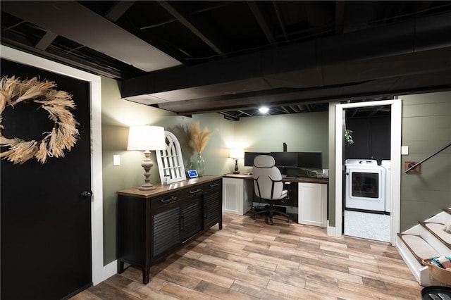 home office with light hardwood / wood-style floors and washing machine and clothes dryer