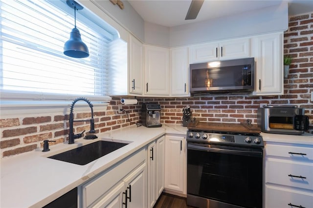 kitchen featuring white cabinetry, appliances with stainless steel finishes, sink, and pendant lighting