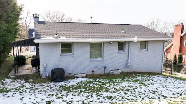 view of snow covered back of property