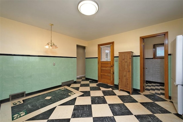 unfurnished room featuring tile walls