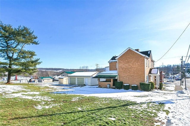 rear view of property featuring a garage and an outdoor structure