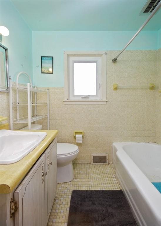 full bathroom with tile walls, shower / washtub combination, vanity, tile patterned floors, and toilet