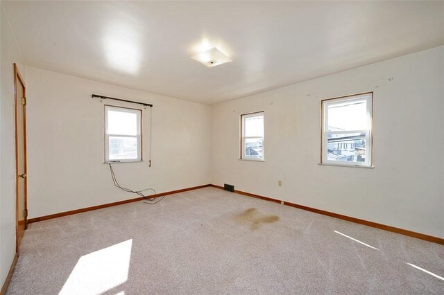 unfurnished room with a healthy amount of sunlight and light carpet