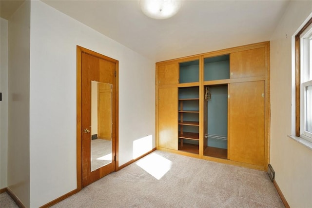 unfurnished bedroom with light carpet and a closet