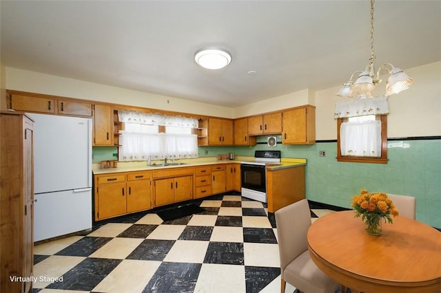 204 Liberty St, Perryopolis, PA 15473 - kitchen featuring range with electric cooktop, freestanding refrigerator, dark floors, a sink, and a chandelier