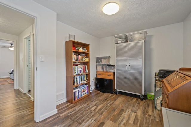 office area featuring ceiling fan, dark hardwood / wood-style floors, and a textured ceiling