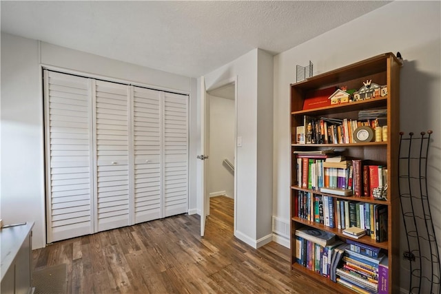 bedroom with dark hardwood / wood-style floors and a textured ceiling