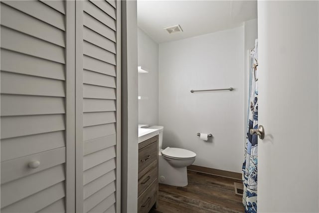 bathroom with hardwood / wood-style flooring, vanity, and toilet