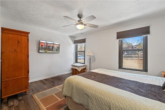 bedroom featuring dark hardwood / wood-style floors, a textured ceiling, and ceiling fan