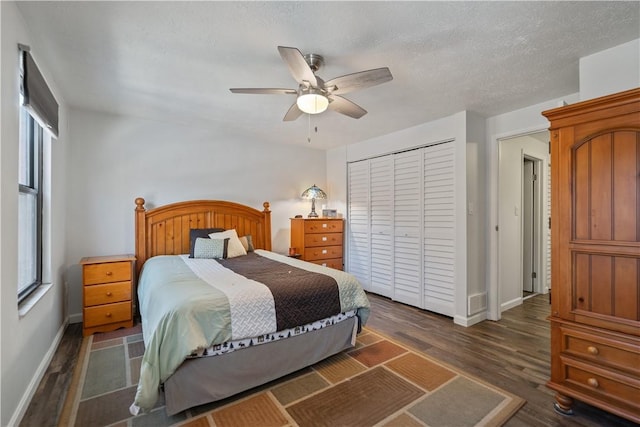 bedroom featuring dark hardwood / wood-style flooring, a textured ceiling, a closet, and ceiling fan