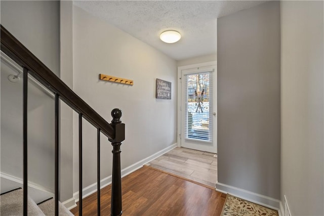 entryway with wood-type flooring and a textured ceiling