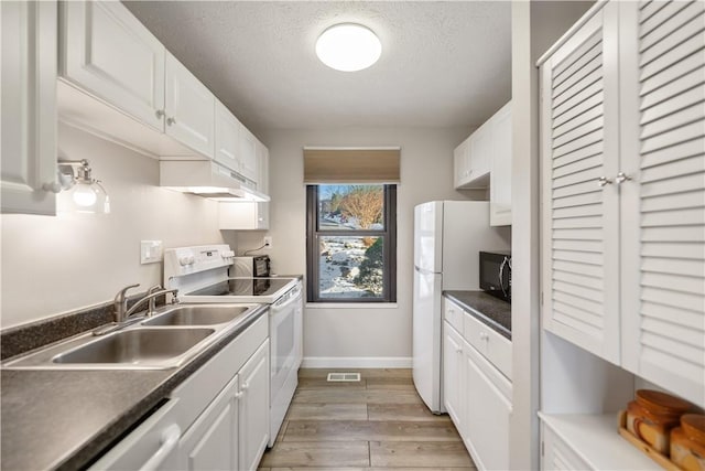 kitchen with sink, white appliances, white cabinetry, a textured ceiling, and light wood-type flooring