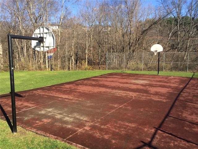 view of sport court with a lawn