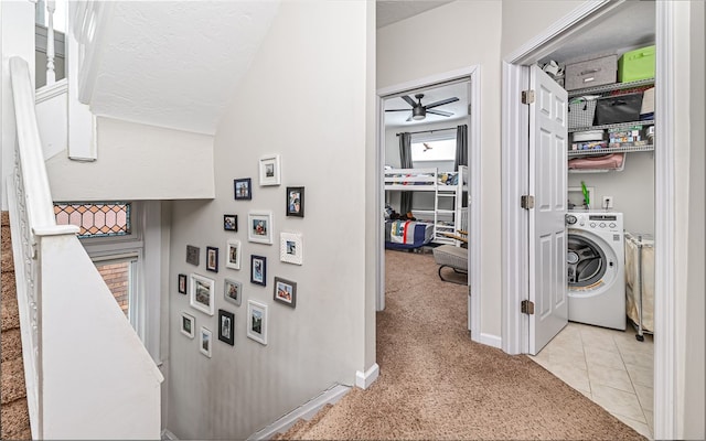 corridor with light carpet, washer / dryer, lofted ceiling, and a textured ceiling