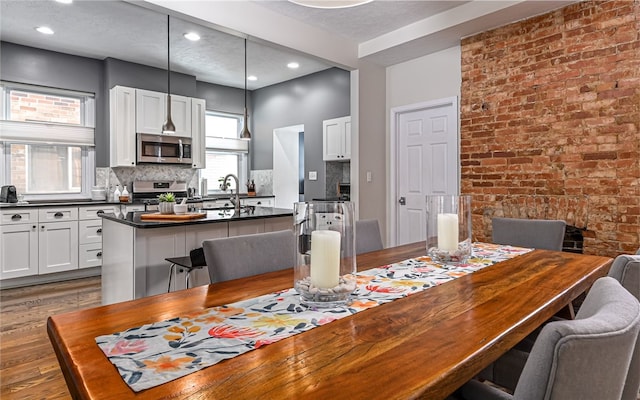 dining room featuring sink, dark wood-type flooring, and a textured ceiling