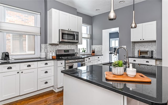 kitchen with white cabinetry, appliances with stainless steel finishes, and backsplash