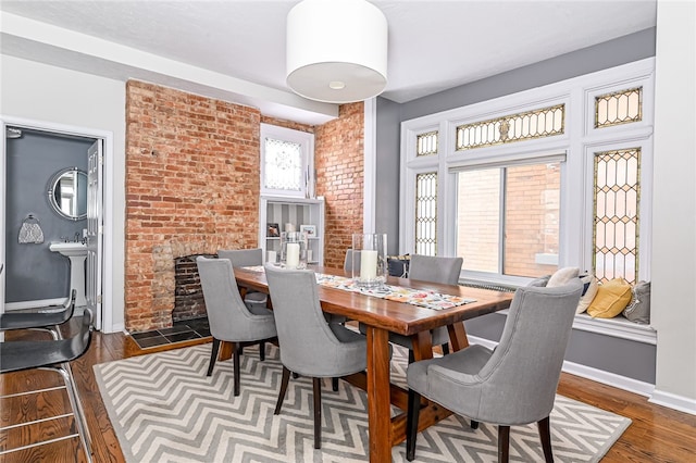 dining space with a fireplace and dark wood-type flooring