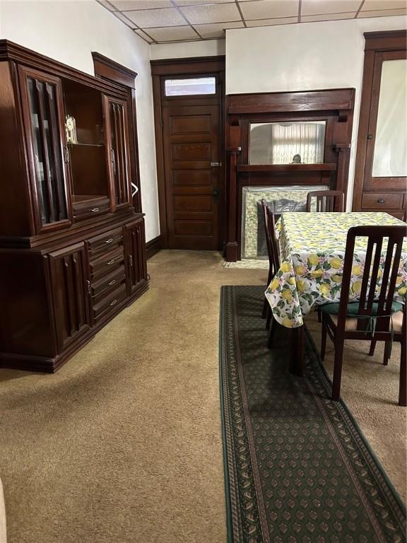 carpeted dining space featuring a paneled ceiling