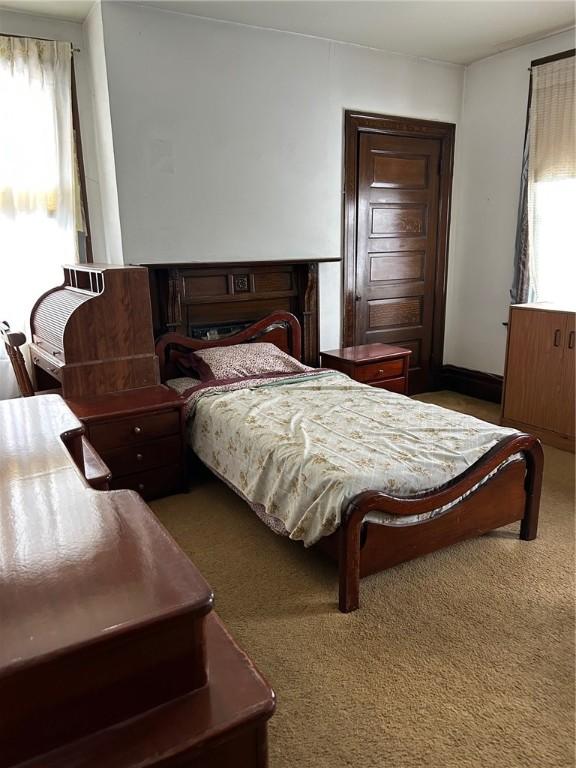 bedroom featuring multiple windows and dark carpet