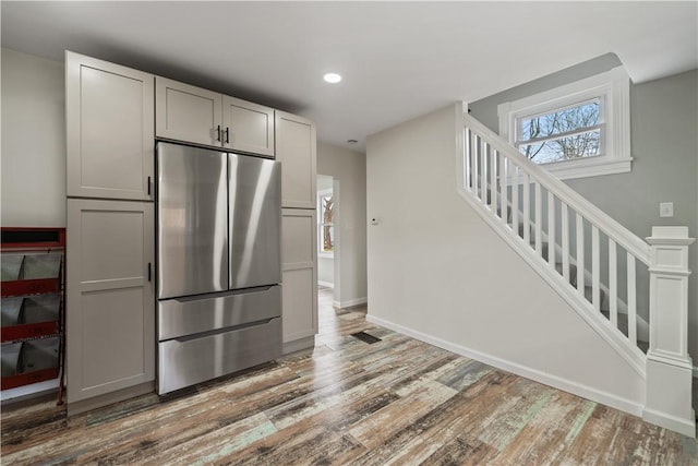 kitchen with hardwood / wood-style floors, gray cabinetry, and stainless steel fridge