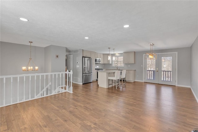 interior space with a healthy amount of sunlight, hardwood / wood-style floors, and a notable chandelier