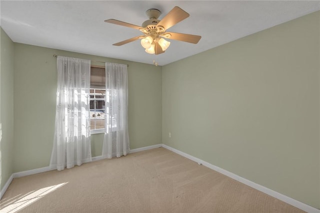 spare room with ceiling fan and light colored carpet