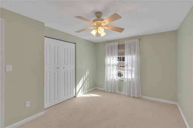 unfurnished bedroom featuring ceiling fan, light carpet, and a closet