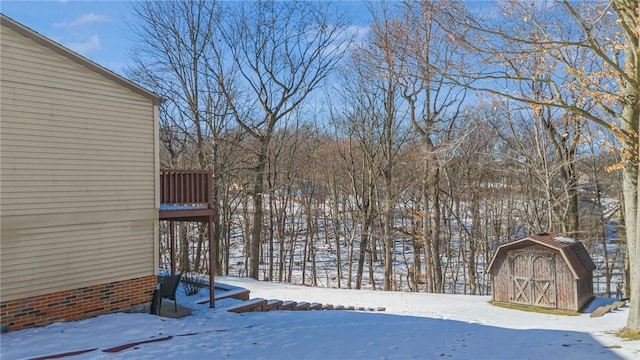 yard layered in snow with a storage shed