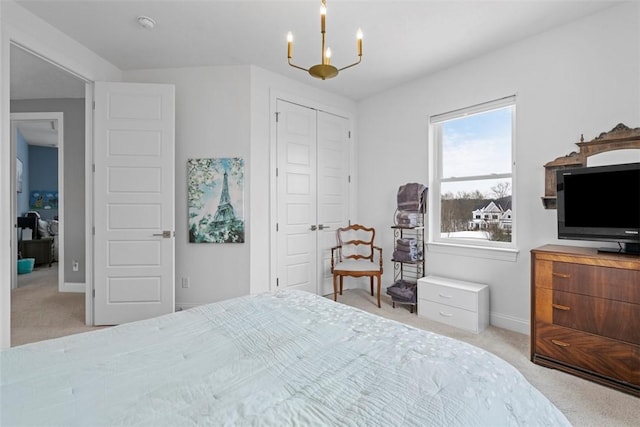 carpeted bedroom featuring a chandelier and a closet