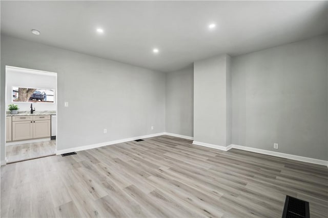 unfurnished room featuring sink and light hardwood / wood-style flooring