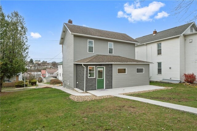 rear view of house featuring a yard and a patio