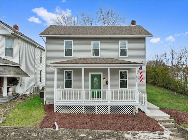 front facade featuring cooling unit, a front yard, and a porch