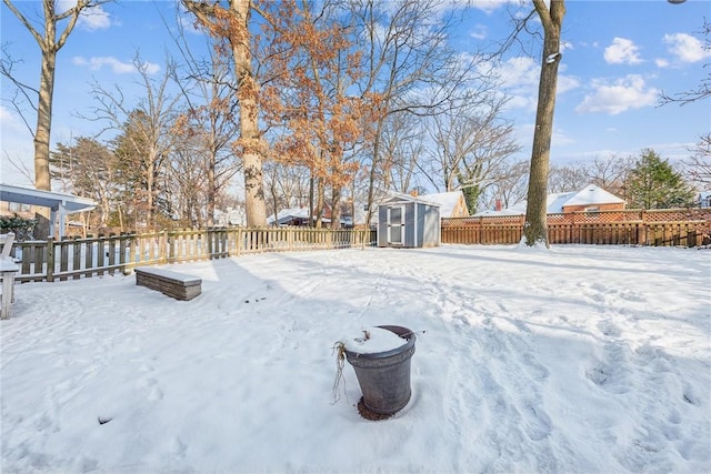 yard layered in snow with a storage unit