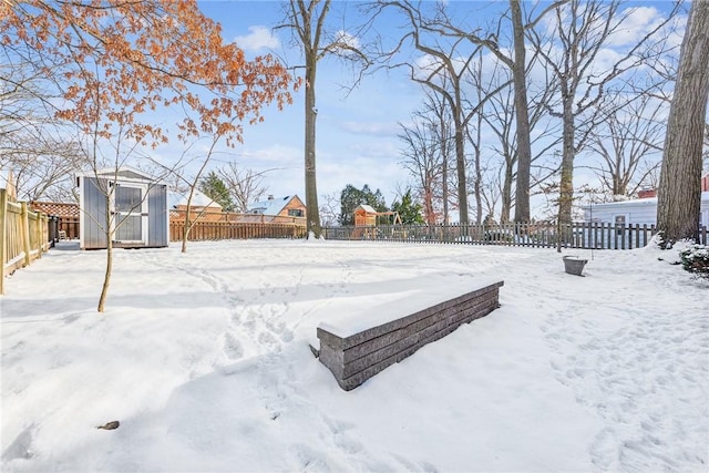 yard covered in snow featuring a shed