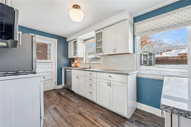 kitchen with sink, appliances with stainless steel finishes, white cabinets, dark hardwood / wood-style flooring, and decorative backsplash