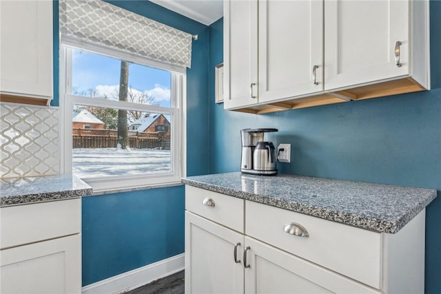 kitchen featuring white cabinetry, dark hardwood / wood-style floors, light stone counters, and backsplash