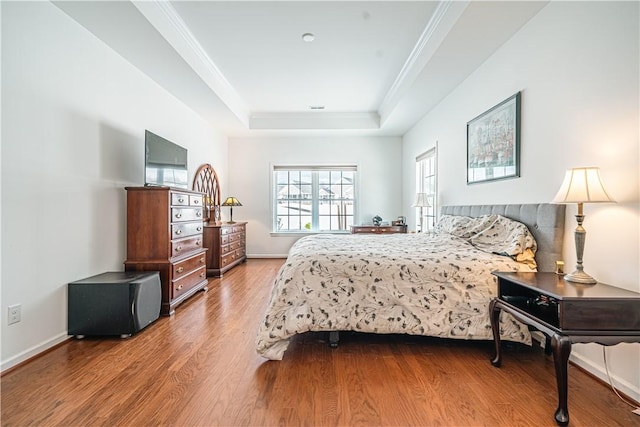 bedroom featuring hardwood / wood-style floors and a raised ceiling